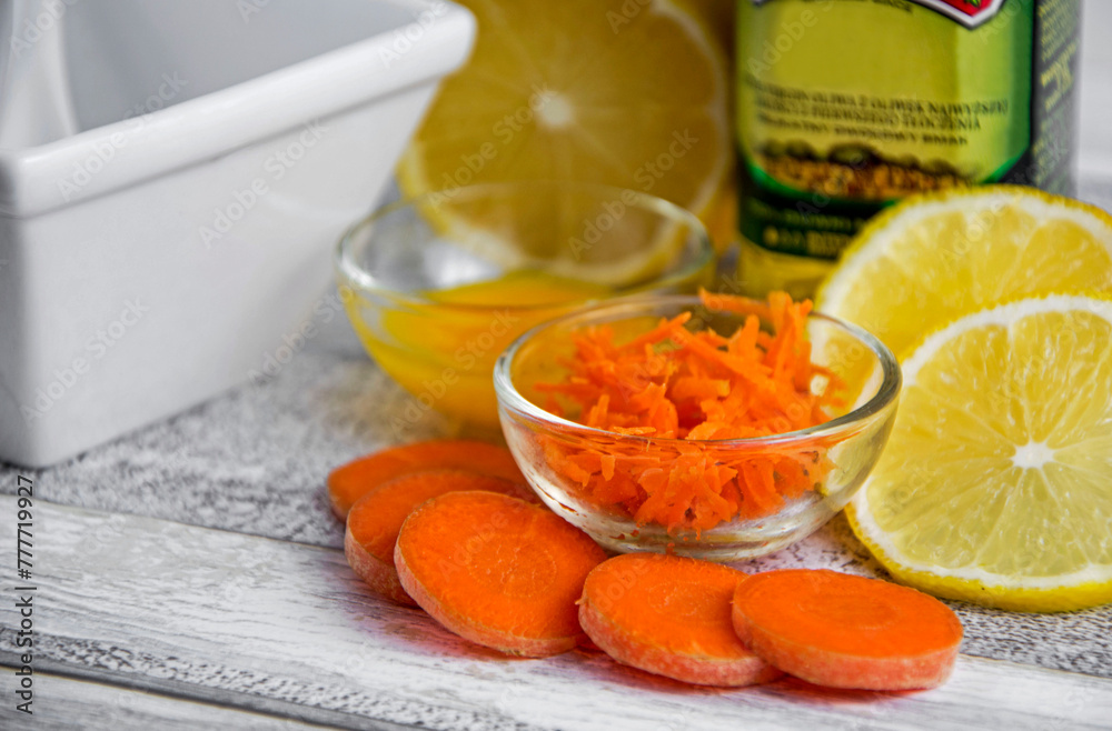pokrojona w plasterki i starta na wiórki marchew, żółtko, cytryna i oliwa jako składniki na maskę lub sałatkę, sliced carrot, yolk, lemon and olive oil, ingredients for a natural cosmetic mask