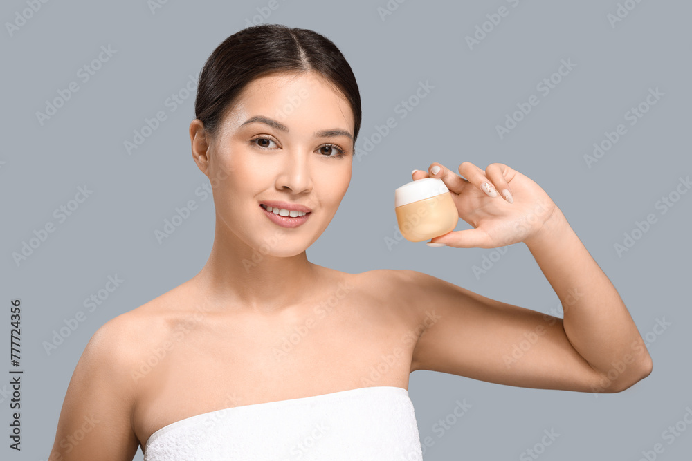 Young Asian woman with jar of facial cream on grey background, closeup Young Asian woman with jar of facial cream on grey background, closeup
