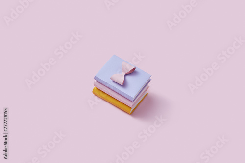 Papercraft composition of three stacked books with pretty pink bow photo