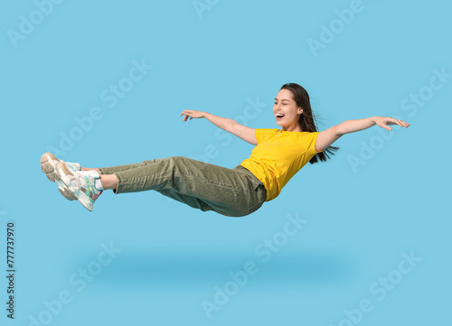 Joyful young woman flying o...