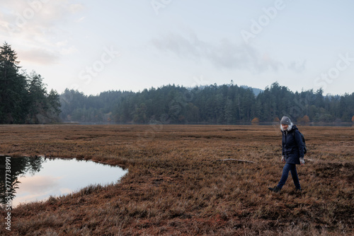 Woman walking outside at the marsh in winter.