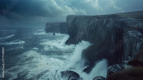 The dramatic cliffs of a rugged coastline, with waves crashing against the rocks below. The angle captures the raw power of the sea and the steadfastness of the cliffs, all under a brooding sky