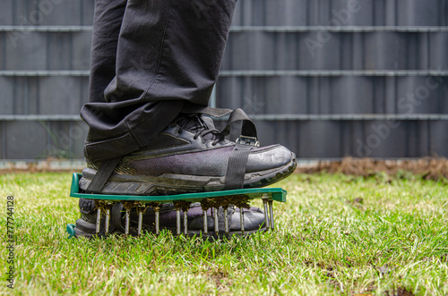 Close-up of lawn aerating shoes with metal spikes.