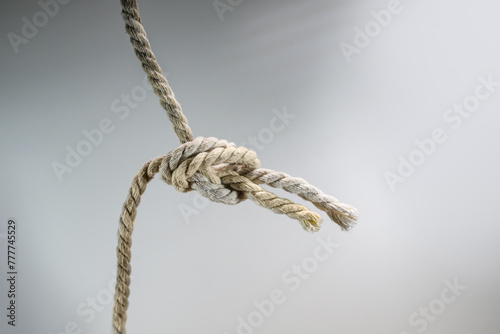 Two ropes are tied together in a knot, business concept for teamwork and cooperation, gray background, copy space