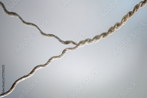 Two strands of yarn are twisted together to form a strong rope, business concept for teamwork, cooperation and partnership, gray background, copy space