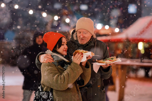 Street Eats Bliss: Couple Sharing Langos on the Go photo