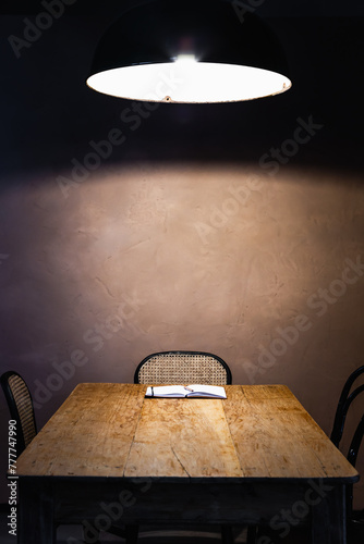 Blank notebook on a rustic table under a pendant lamp photo