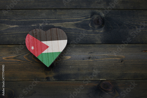 wooden heart with national flag of jordan on the wooden background.