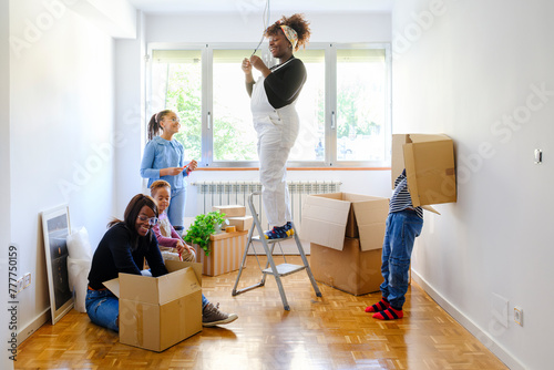 Members of family unpacking boxes in new home photo