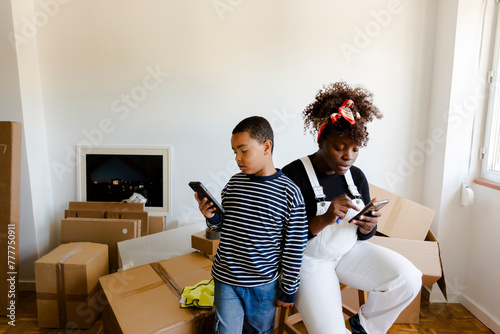 Mother and son using smartphones while moving in photo