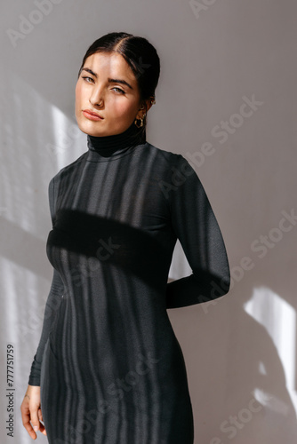 Stylish lady in black turtleneck dress in studio photo