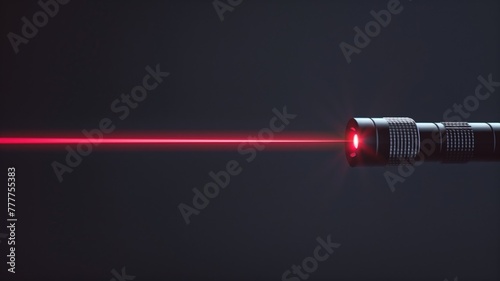 Red laser beam projecting from metal pointer against dark background