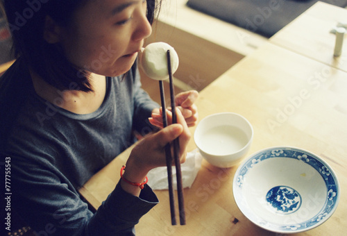 Women sit and eat steamed buns
 photo