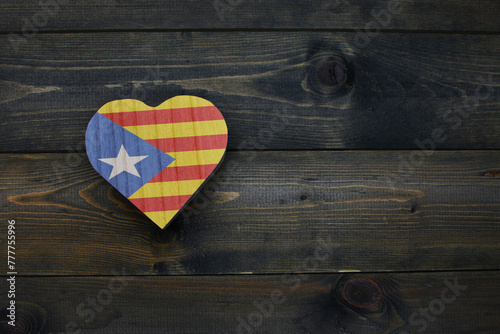 wooden heart with national flag of catalonia on the wooden background.