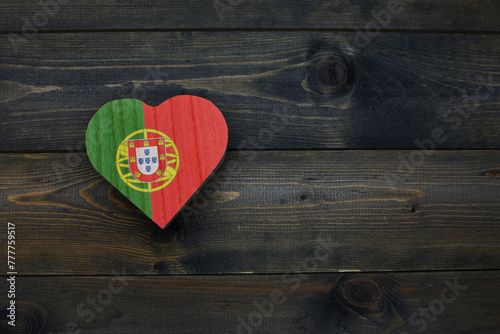 wooden heart with national flag of portugal on the wooden background.