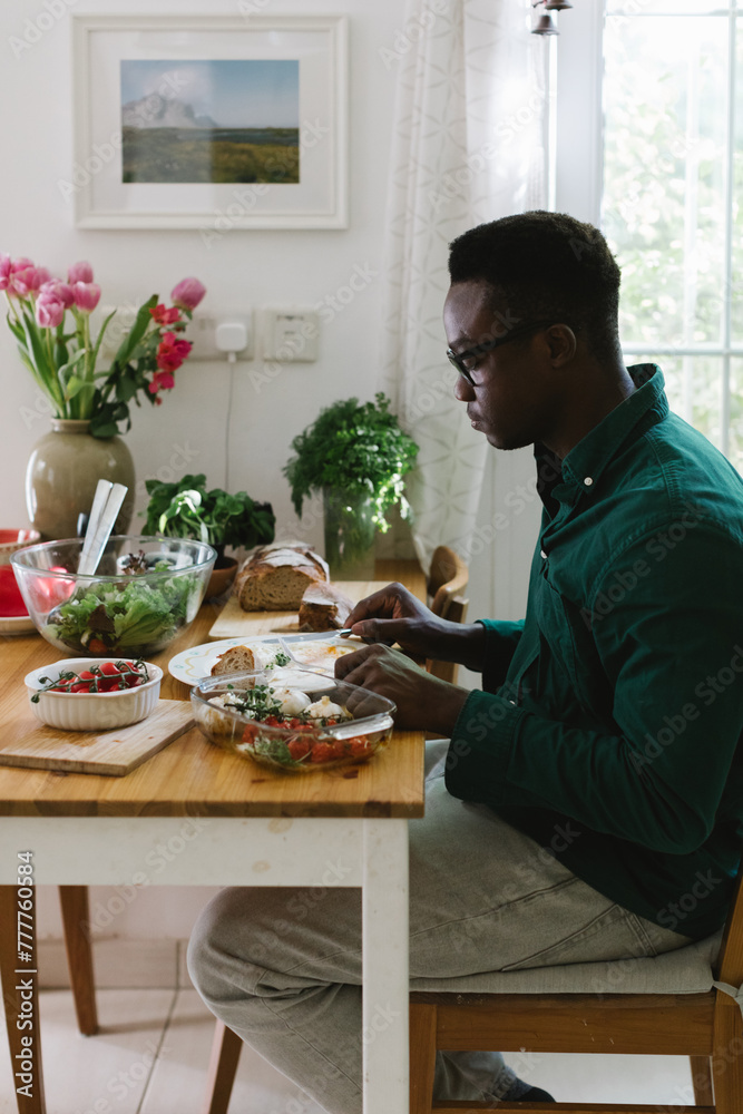 A man is eating breakfastat home A man is eating breakfastat home