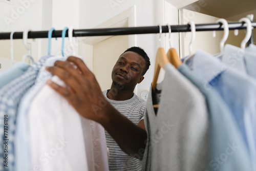 A young man choosing clothes to wear photo