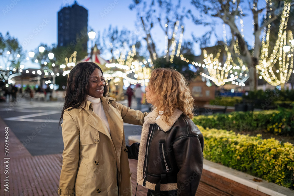 multiracial friends walking through the city at night multiracial friends walking through the city at night