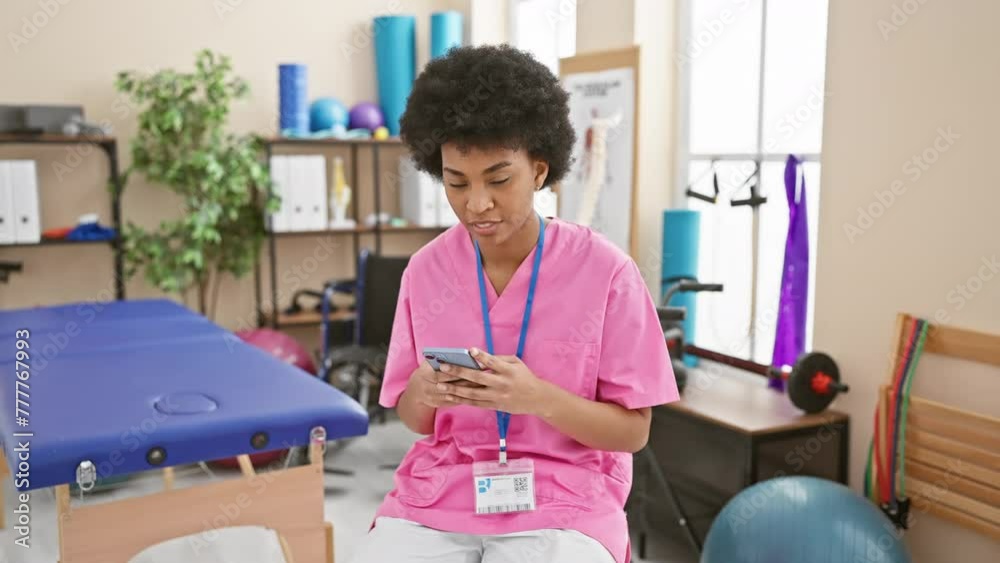 Cheerful african-american woman at rehab clinic exuding positive energy, excitedly marking point on smartphone with a confident smile Cheerful african-american woman at rehab clinic exuding positive energy, excitedly marking point on smartphone with a confident smile