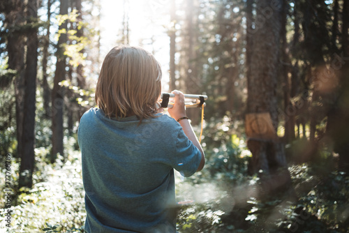 boy playing with blowpipe in the woods