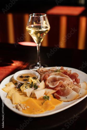 set of cheese, nuts and ham with glass of wine