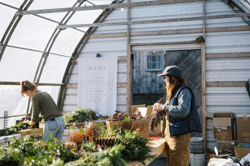 female farm workers making holiday decor together for small business  photo