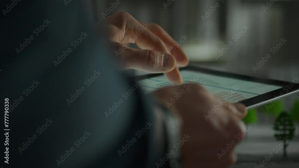 A company employee uses an electronic tablet while working with digital information. Close-up of a manager's hands holding a touchpad. Analyzes growth process data A company employee uses an electronic tablet while working with digital information. Close-up of a manager's hands holding a touchpad. Analyzes growth process data