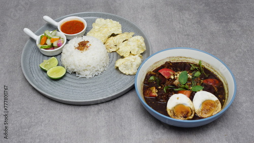 
White rice, pickles, lime, chips, vegetables, meat, black pepper, plus eggs, cooked with typical Indonesian spices