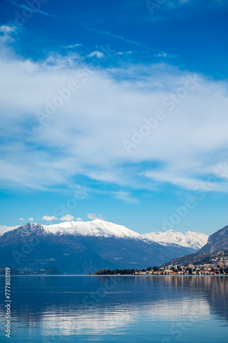 Driving car along shores of Lake Como in Northern Italy  spring sunny days  views of alpine mountains  water and villages