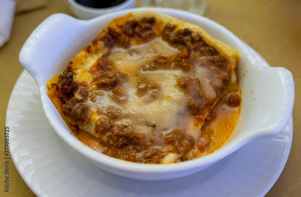 Traditional first course for lunch or dinner in Italy, lasagne Bolognese with beef meat and bechamel sauce served in Italian restaurant, Milan, Italy Traditional first course for lunch or dinner in Italy, lasagne Bolognese with beef meat and bechamel sauce served in Italian restaurant, Milan, Italy