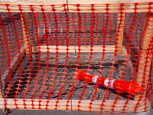 Red plastic mesh around some ground works in a path