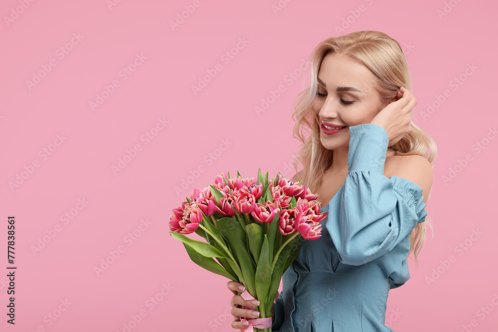 Happy young woman with beautiful bouquet on dusty pink background. Space for text Happy young woman with beautiful bouquet on dusty pink background. Space for text