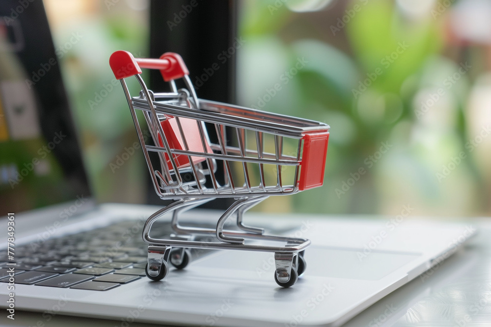 miniature shopping cart with packaging standing on the laptop. online shopping concept, spending, CPI. High quality photo miniature shopping cart with packaging standing on the laptop. online shopping concept, spending, CPI. High quality photo