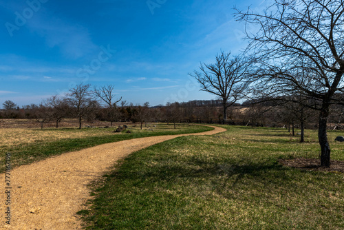 A winding dirt trail through a field in the Gettysburg National Military Park on a sunny winter day