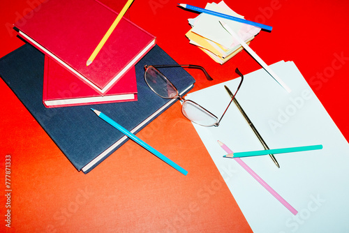 Business office desk with glasses, post it, papers, pencils and books  photo