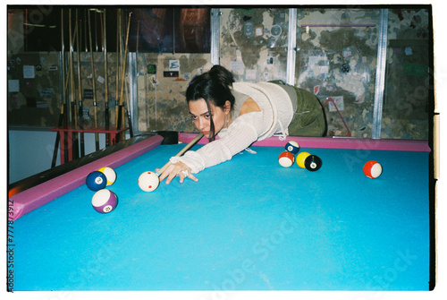 young woman plays billiard photo