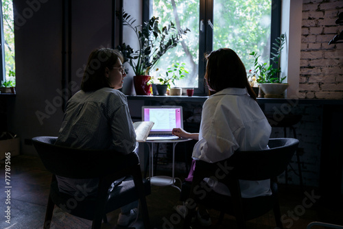Two business women discuss a project in a cafe photo