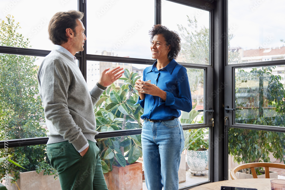 © ALTO IMAGES/Stocksy - Multiracial coworkers chatting near panoramic window © ALTO IMAGES/Stocksy - Multiracial coworkers chatting near panoramic window