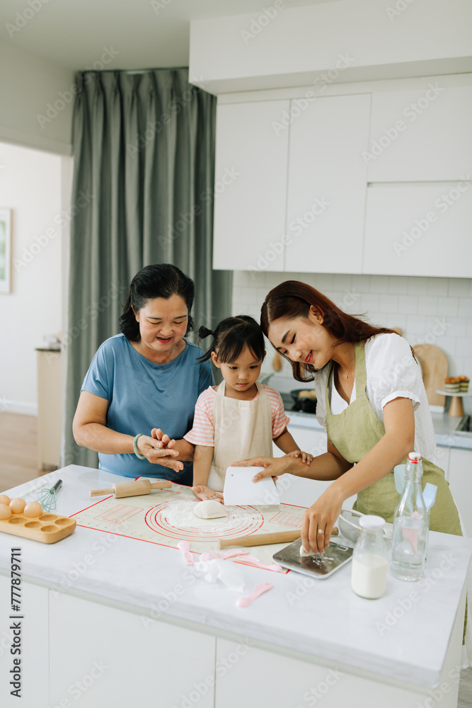 Little girl with mom and grandma making dough Little girl with mom and grandma making dough