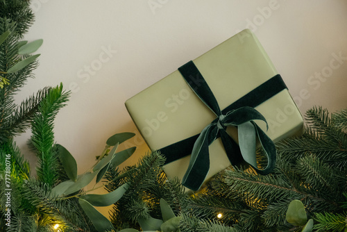 Wrapped Christmas present near fir branches