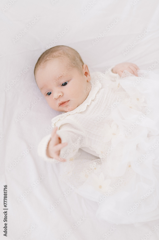 awake newborn baby girl on white bed sheet awake newborn baby girl on white bed sheet