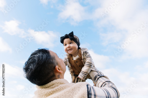 mother throwing smiling daughter up into the air photo
