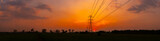 Panorama Silhouette street light post, electric pole and high voltage tower.High voltage transmission pole against evening sunset sun background.
