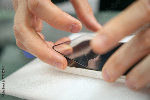 Man removing a mobile broken screen protector photo