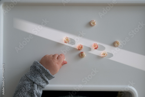 Baby boy reaching for cereal snacks. photo
