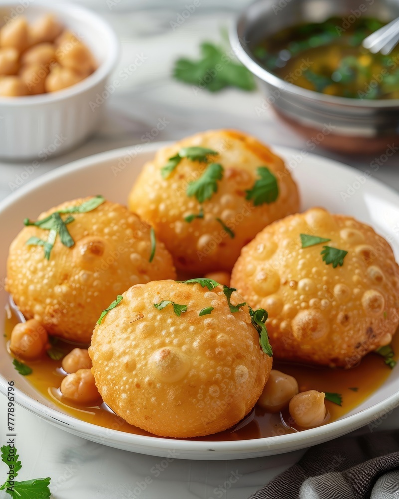 Crispy pani puri, a classic Indian street snack, garnished with cilantro in a wooden bowl on white. Crispy pani puri, a classic Indian street snack, garnished with cilantro in a wooden bowl on white.