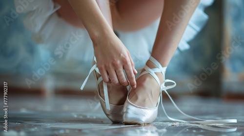 close-up of classic ballerina tightening her pointe shoe, ballet class photo