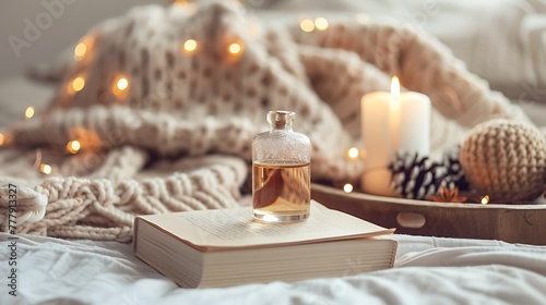 Liquid home fragrance stay on paper book with knit cloth sweater on wooden tray in bedroom in bed over glow christmas