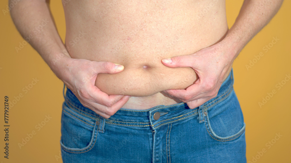 Naklejka premium Man assessing his belly fat problem