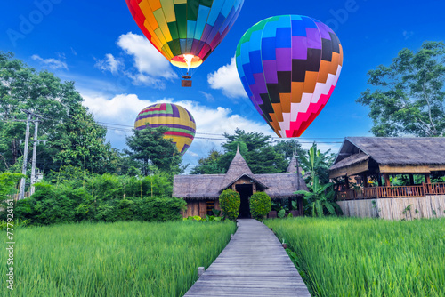 Wooden walkway and balloons with green rice fields in Vang Vieng, Laos.